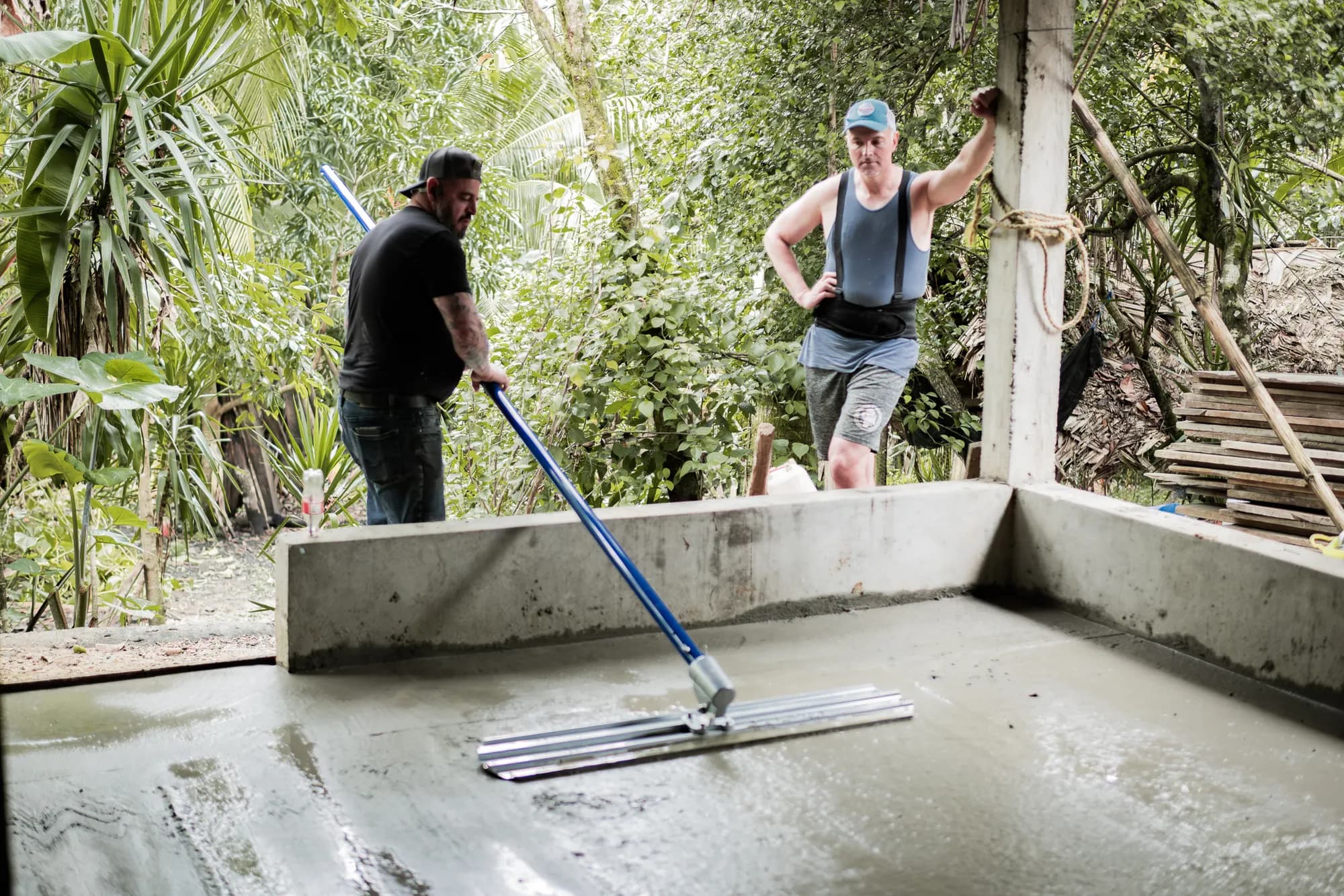 Volunteers smooth a new concrete floor at a family home.