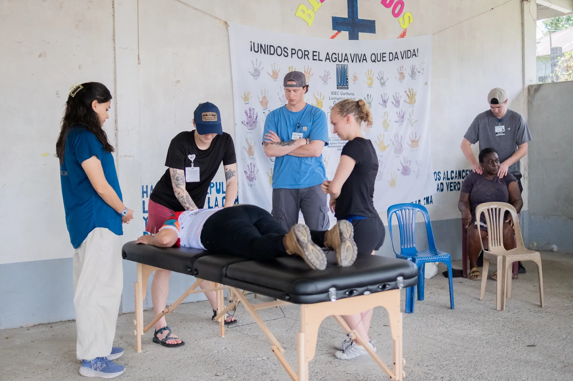 Visiting healthcare volunteers demonstrate a physical therapy technique.