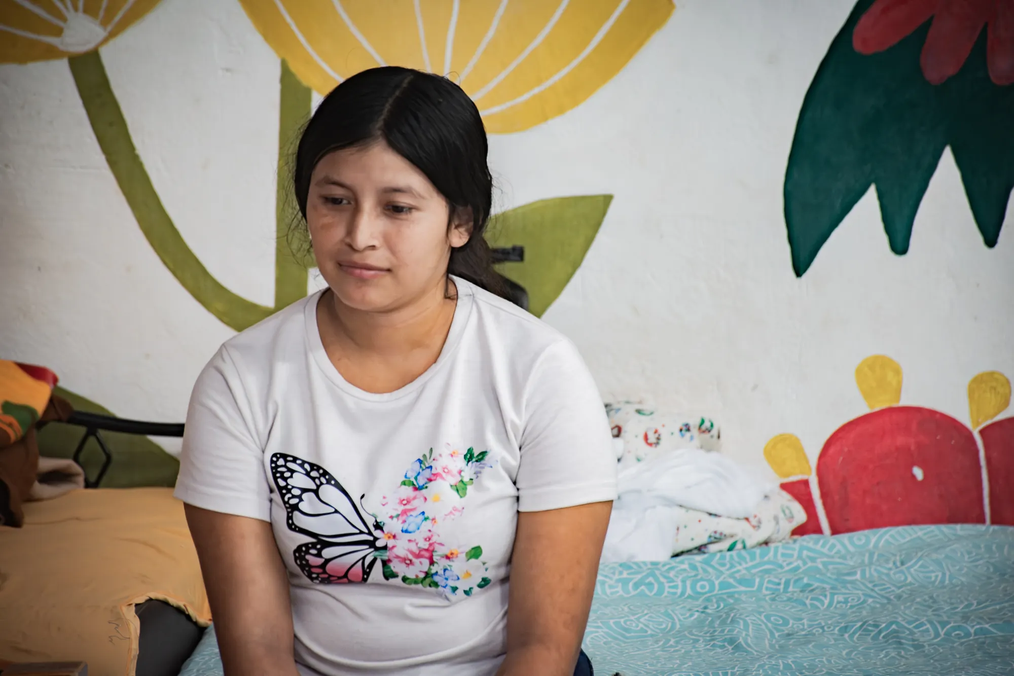 A young woman is welcomed inside an El Faro community space.