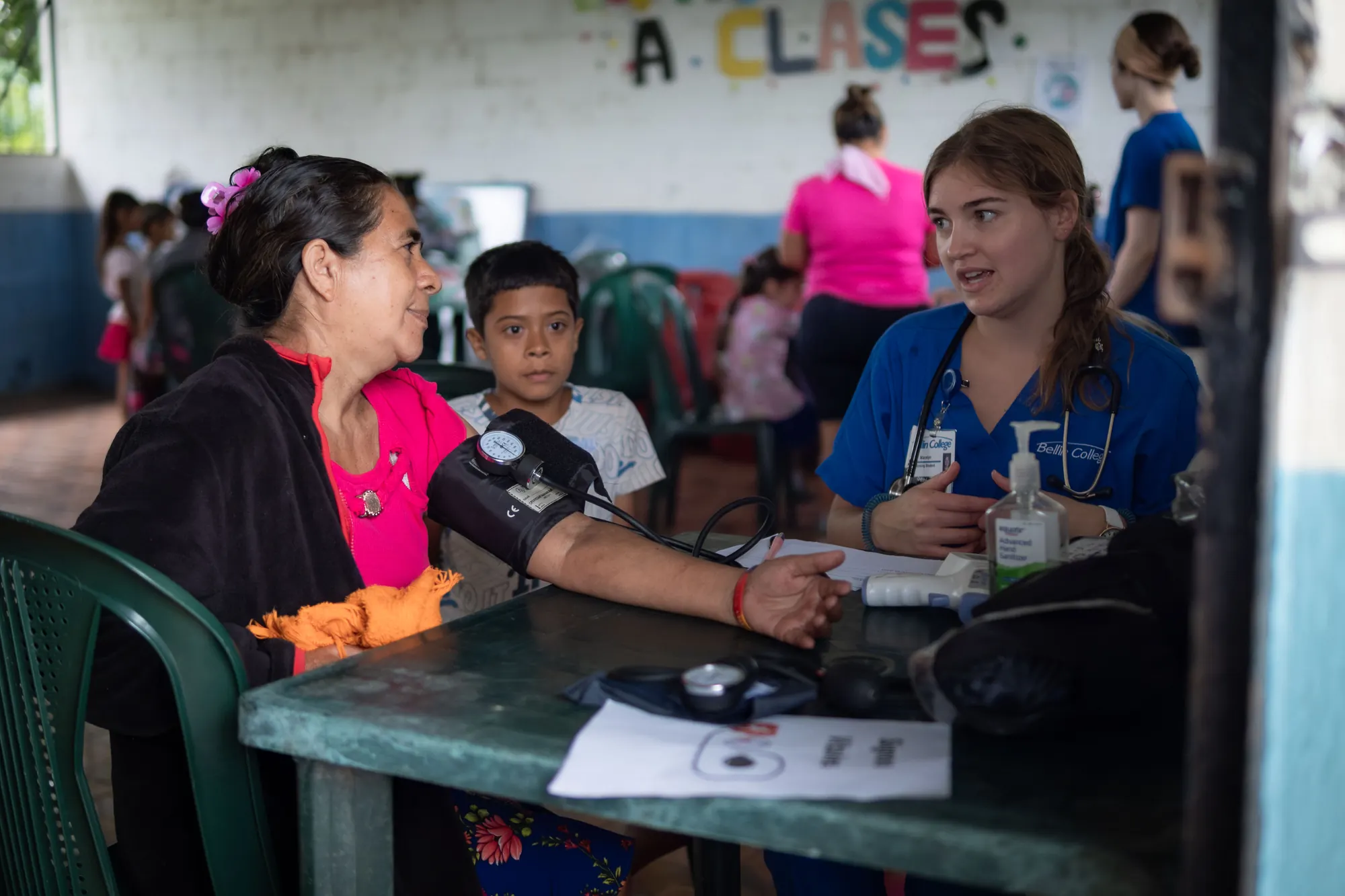 A mission team member speaks with a mother during a community clinic.