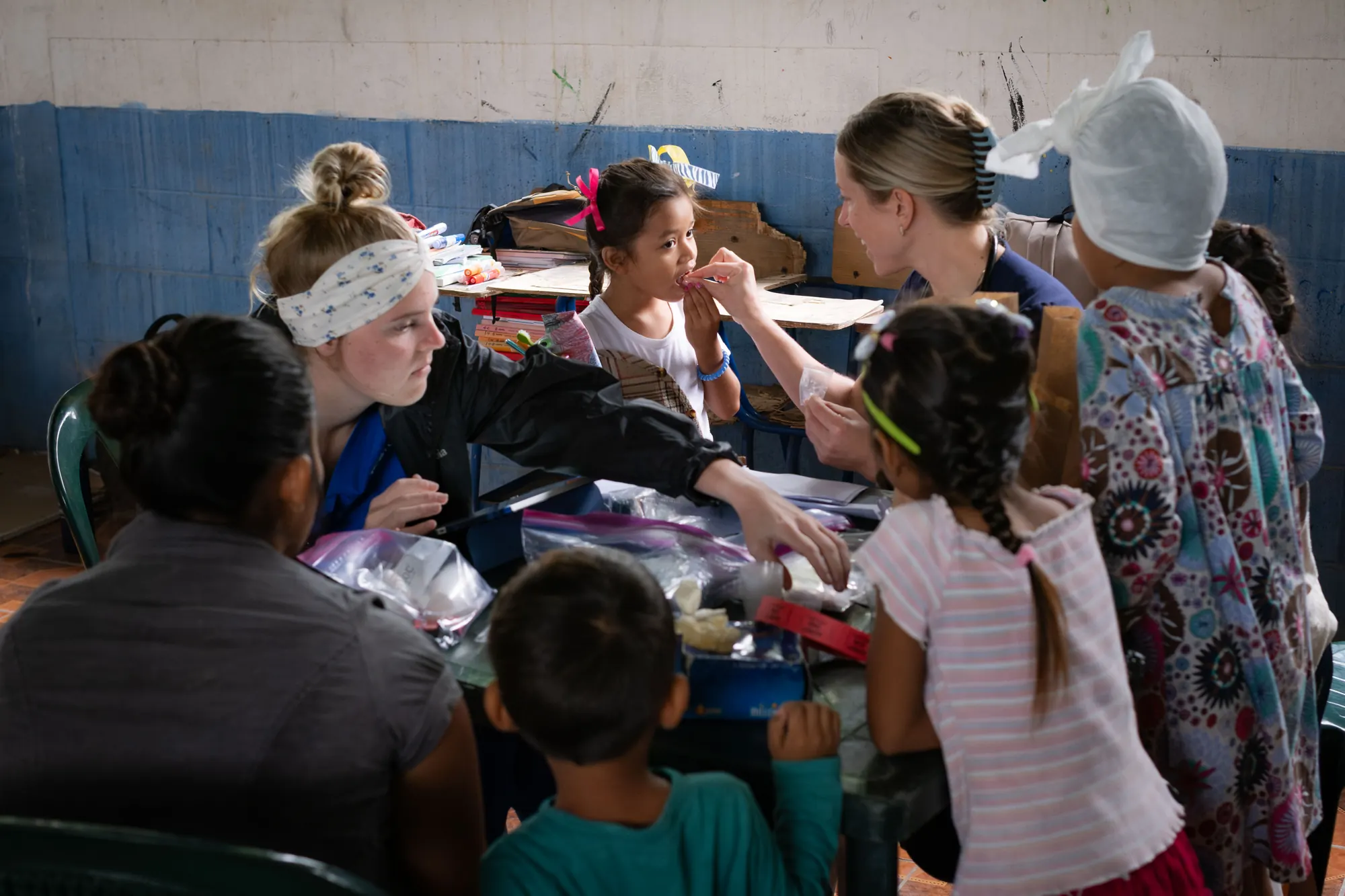 Volunteers gather closely with children during a day of service.