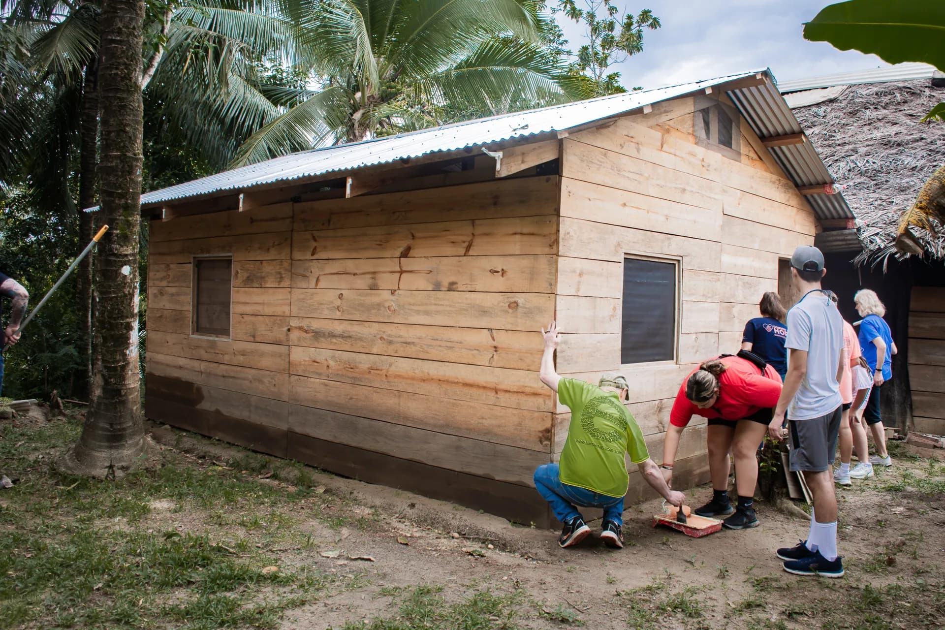 Volunteers and local partners work together outside a family home.