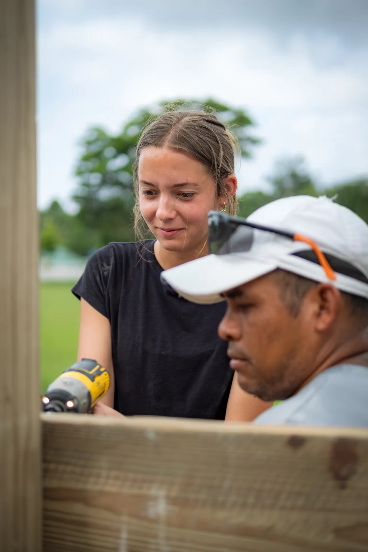 A volunteer and local carpenter work together on a building project.