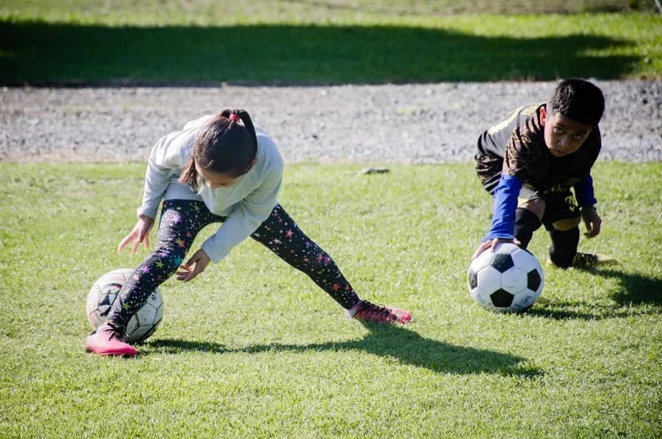 Children play soccer on the El Faro campus.