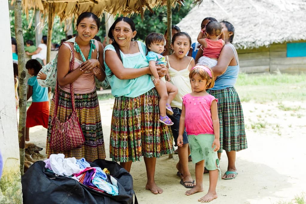 Women and children gather during an El Faro community visit.