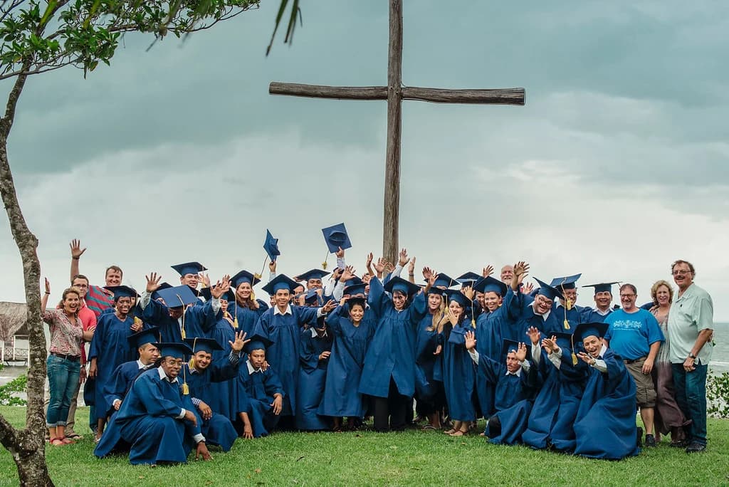 Graduates celebrate beside the El Faro cross.