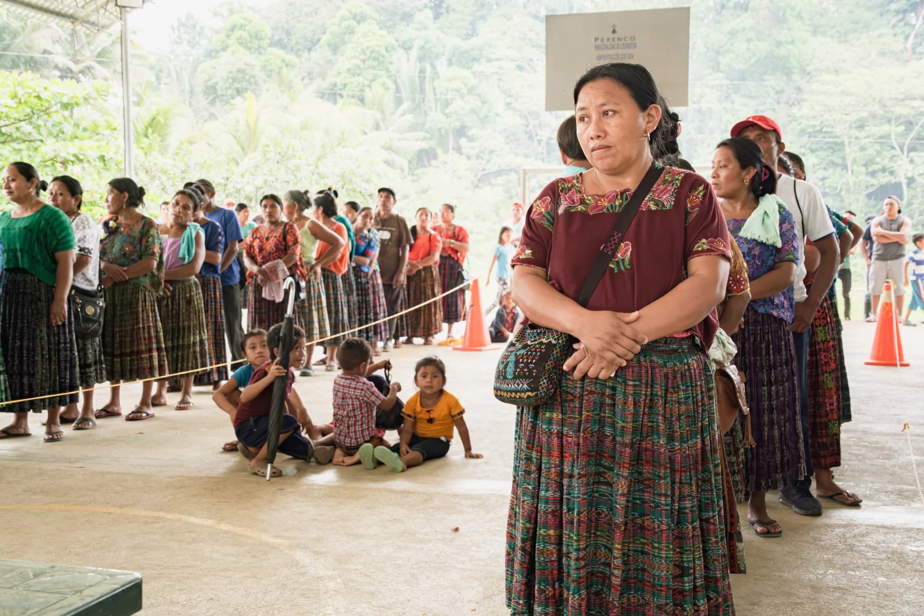 A woman stands before a community gathering in Tameja.